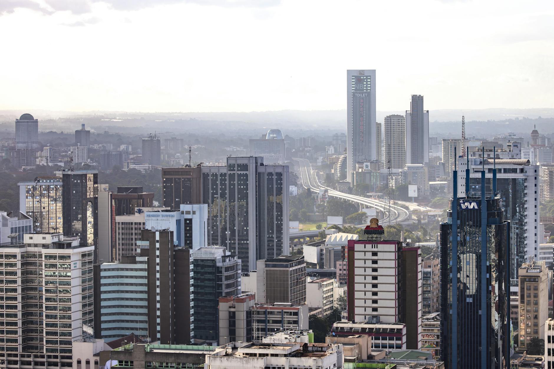 Aerial view of Nairobi's modern skyscrapers and bustling urban landscape under a clear sky.