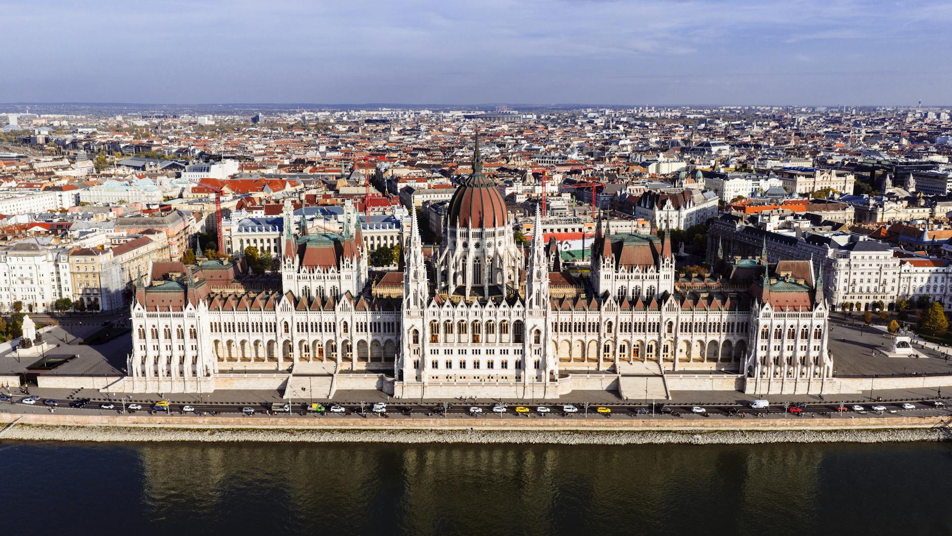 Drone shot showcasing the grandeur of Budapest's Parliament Building along the Danube River.