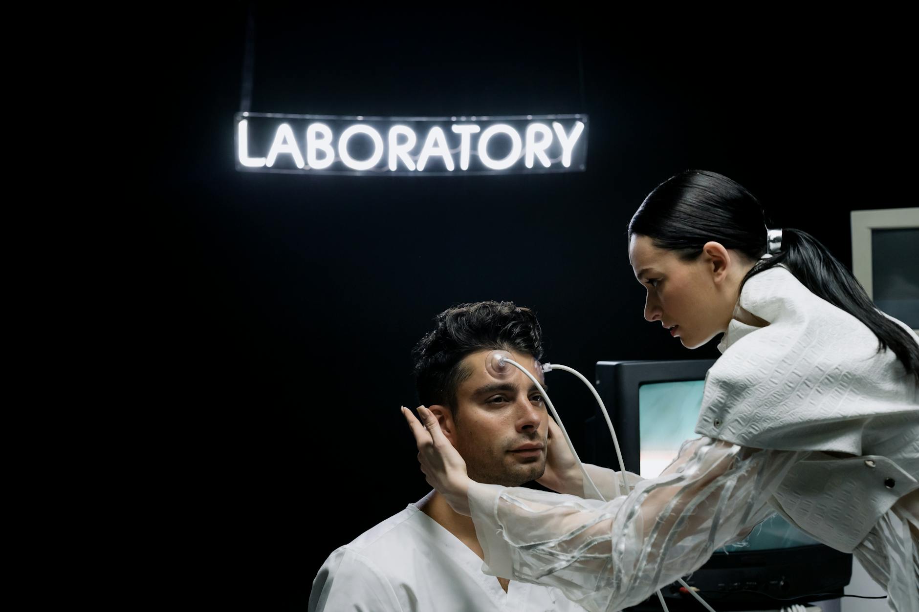A woman conducts a medical examination on a man in a futuristic laboratory.